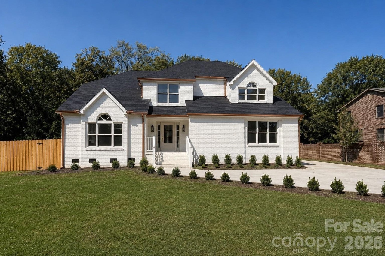 Front exterior of the renovated white brick home at 4818 Carmel Road